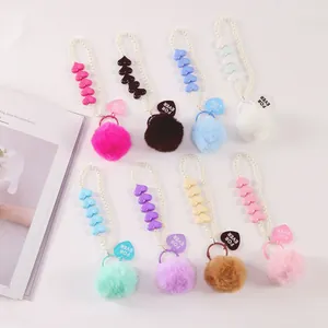 Detail of 8 colorful faux fur pompom keychains with pearls and heart-shaped charms