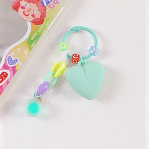 Dettaglio del portachiavi a cuore verde menta con catena colorata e perline smiley