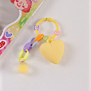 Dettaglio portachiavi a cuore colorato con ciondolo giallo opaco e catena multicolore