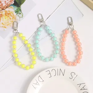 Detailed shot of pastel acrylic beaded keychains in yellow, blue, and pink candy colors