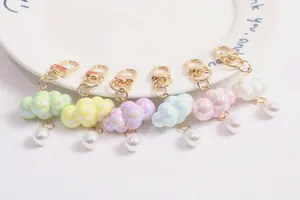 Dettaglio di sei portachiavi a nuvola colorati con perle e moschettoni dorati