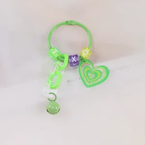 Dettaglio portachiavi a cuore verde con perle a lettere, catena in plastica e campanellino