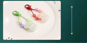 Detail of red and green heart-shaped mahjong keychains with beaded accents and glitter finish