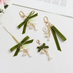 Llavero de cinta de terciopelo verde con lirio de los valles y cadena de perlas blancas