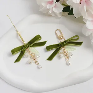 Llavero de lazo de terciopelo verde con flor de lirio y cadena de perlas