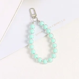Detail of mint green acrylic beads with silver metal clasp on a decorative display card