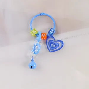Dettaglio portachiavi blu con perline a lettere, catena in plastica e campanellino