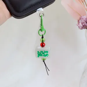 Green Fortune Mahjong charm keychain with crystal beads and metal carabiner on a phone case