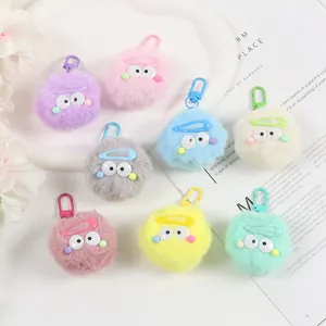 Huit porte-clés pompons colorés avec des yeux mignons sur un plateau blanc décoratif