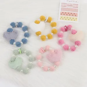 Vue détaillée de cinq bracelets cœur en peluche avec perles aux tons pastels