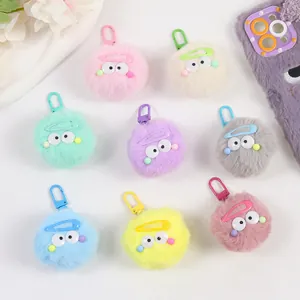 Vue détaillée de porte-clés monstres en peluche colorés avec de grands yeux et crochets