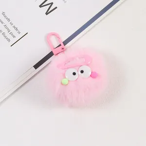 Gros plan d'un porte-clés pompon rose en peluche avec yeux et crochet en plastique