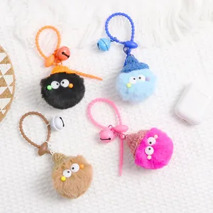Detail of colorful plush monster keychains with knit hats, silicone loops, and small bells