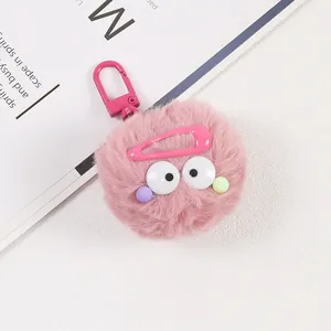 Détail d'un porte-clés monstre en peluche rose avec de grands yeux et un clip métallique