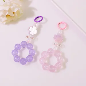 Dettaglio di portachiavi con perline rosa e viola con fiori opachi e piccoli fiocchi