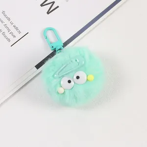 Gros plan d'un porte-clés en peluche vert menthe avec de grands yeux et une barrette