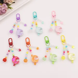 Macro view of macaron-colored moon keychains with bead chains in seven assorted colors