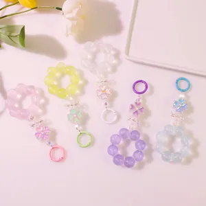 Dettaglio di cinque portachiavi colorati con perline floreali, ciondoli e clip metallici