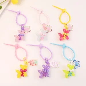 Flat lay showing six colorful balloon dog keychains with charms and tulip tags