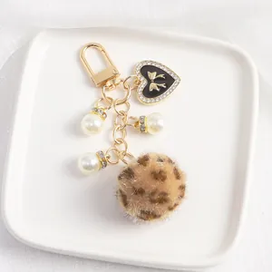 Détails du pendentif cœur, perles blanches et porte-clés à pompon imprimé léopard