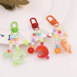 Detail of colorful beaded keychains with moon pendants and transparent acrylic beads