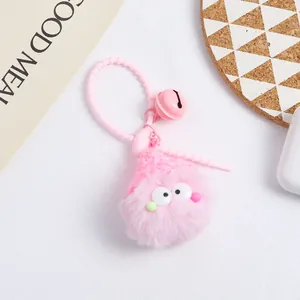 Close-up of pink fluffy monster keychain with soft gel ring and bell accessory