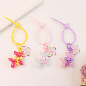 Flat lay of colorful jelly balloon dog keychains with floral charms and silicone straps