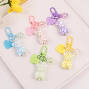 Macro view of colorful luminous bear pendants with heart tags and pearl charms in five colors