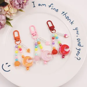Close-up of candy-colored beaded keychains with moon stars and heart charms in three vibrant colors