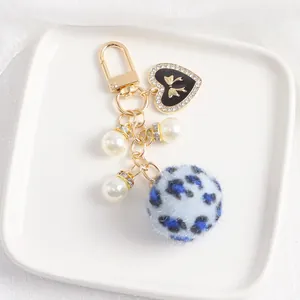 Détails du porte-clés à pompon bleu léopard avec pendentif coeur doré et perles fines