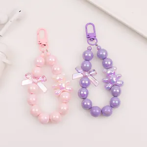 Close-up of cute cartoon bear beaded keychain with pink and purple iridescent beads
