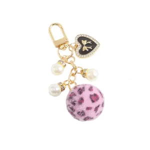 Porte-clés pompon léopard avec chaîne dorée, pendentif coeur émaillé et perles blanches