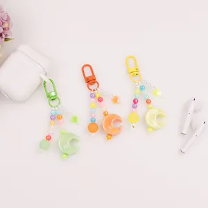 Detailed view of colorful moon and star beaded keychains in green, orange and yellow