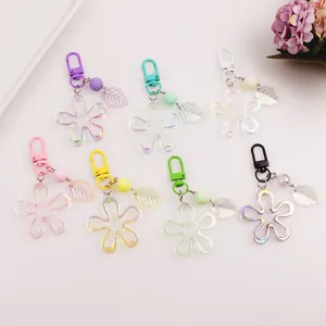 Flat lay of seven colorful acrylic flower keychains with metallic clasps and leaves
