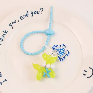 Gros plan du porte-clés chien ballon jaune translucide avec pendentif fleuri sur une assiette