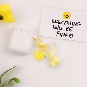 White earphone case with luminous yellow bear charm and heart tag for AirPods