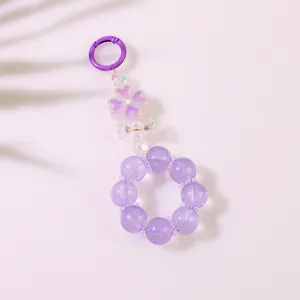 Dettaglio portachiavi a perle viola con pendenti in resina a forma di fiori e fiocchi