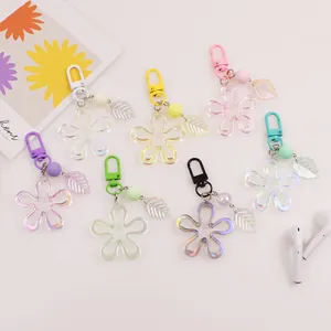 Flat lay of colorful iridescent flower keychains with frosted beads and acrylic leaf charms
