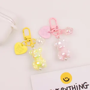 Detailed close-up of rainbow resin bear keychains in pink and yellow with heart tags