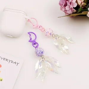 Detail of holographic leaf pendants and rhinestone beads on pink and purple keychains