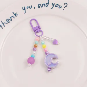 Detail of purple moon and heart beaded keychain with iridescent beads and lobster clasp