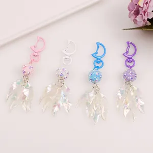 Detail of four colorful moon keychains with sparkling beads and laser iridescent leaf charms