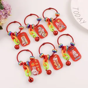 Detailed view of red acrylic rabbit lucky charm keychains with bells and beads