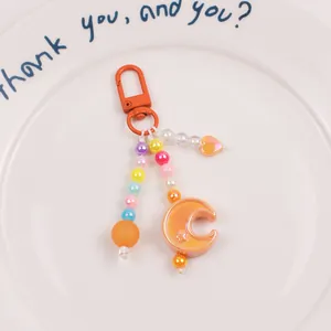 Macro shot of orange beaded moon keychain with colorful stars and heart charms