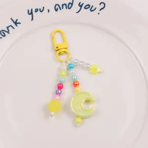 Detail of yellow moon and heart beaded keychain with colorful acrylic beads and star charms