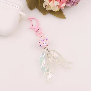 Detail of pink moon keychain with iridescent leaf charms and glitter bead on white background
