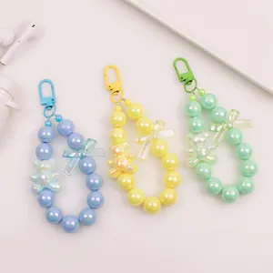 Close-up of beaded keychains with bear pendants in blue, yellow, and mint green hues