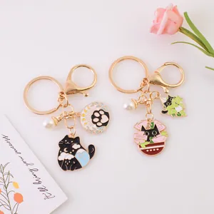 Cartoon black cat keychains with star cloud and cat paw charms in gold alloy and enamel