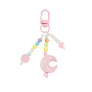 Pastel pink beaded keychain with iridescent moon and heart charms on a white background
