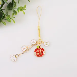 Détail macro du pendentif pomme rouge avec caractères et lettres dorées